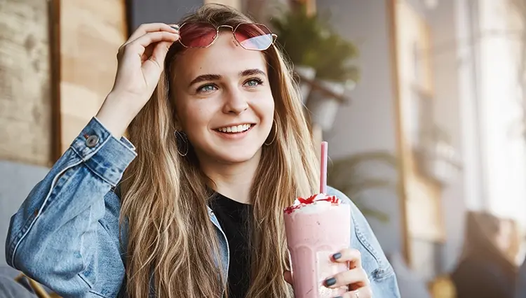 a woman holding a pink Keto Chow shake