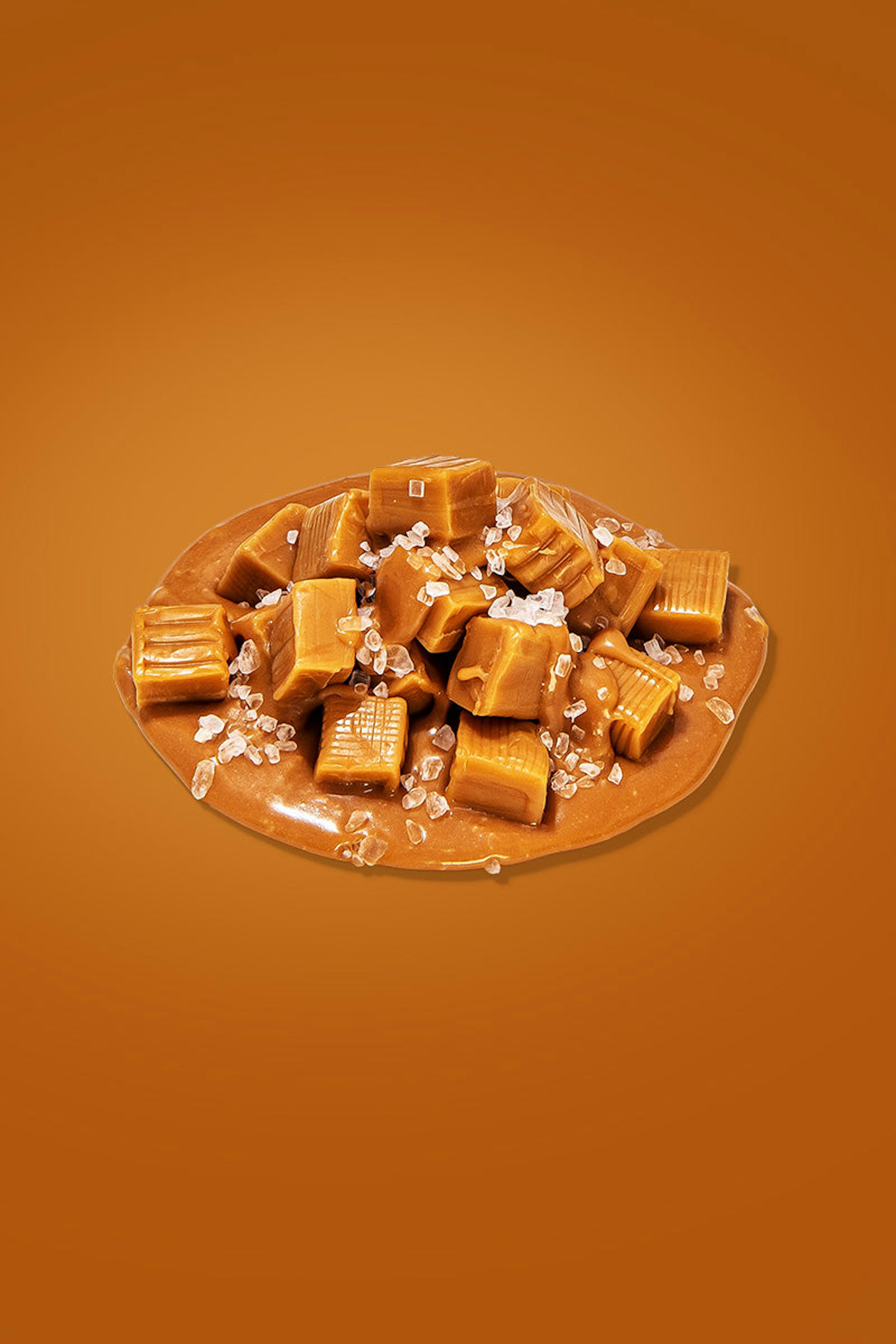 Salted caramel candies sprinkled on top of a thick and creamy caramel sauce