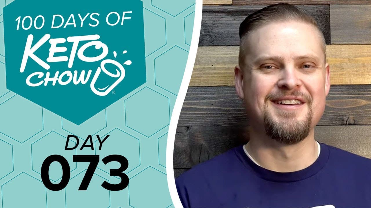 Teal KETO CHOW graphic: 100 DAYS OF KETO CHOW text, blender bottle logo, DAY 073. Smiling bearded man in blue shirt to the right.