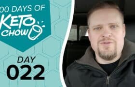 Image displaying a man on the right and a graphic on the left. The graphic, in teal and light blue, features the text 100 DAYS OF KETO CHOW and DAY 022. The Keto Chow brand logo includes a white shaker cup icon.