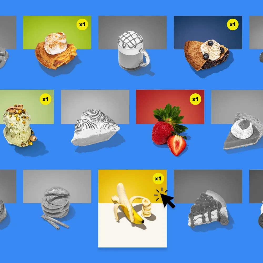 A colorful product selection grid against a blue background. The grid displays individual dessert items, each in its own box. Some boxes are in full color, like a croissant pastry, a coffee drink, and a slice of pie with berries. Other boxes are in black and white. A yellow circle with x1 is in the upper right corner of some boxes. A hand icon with a cursor points to a yellow and white box containing a peeled banana.