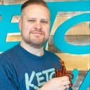 A picture of Chris Bair holding a bouquet of bacon.