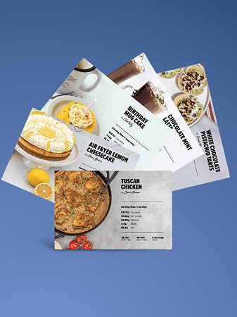 Three recipe cards on a blue background are titled: Air Fryer Lemon Cheesecake, Birthday Mug Cake, and Chocolate Mint Mousse. Also visible is a portion of a recipe card for Tuscan Chicken and White Chocolate Raspberry Tarts.