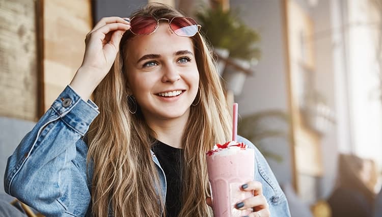 a woman holding a pink Keto Chow shake
