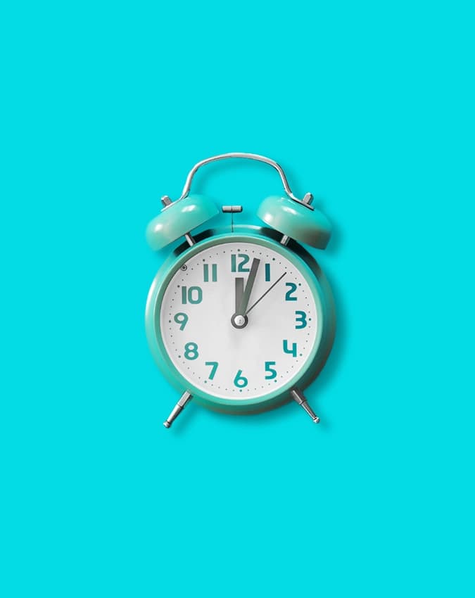A blue alarm clock on a blue background