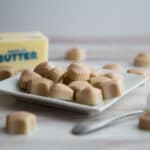 Cream colored Fat Bombs on a white plate.