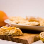 Close up - Guava Grapefruit jelly on a keto cookie, with a plate of cookies in the background.