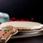 Close up - Gingerbread Keto No-Bake Cheesecake on a white plate. Gingerbread cookie in the front.