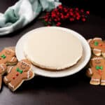 Top view - Gingerbread Keto No-Bake Cheesecake on a white plate. Surrounded by gingerbread cookies.