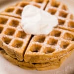 Close up - two Irish Cream Belgian Waffles, topped with whipped cream.