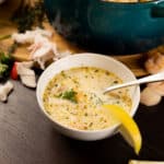 White bowl filled with Seafood Bisque. Lemon wedge on the side.